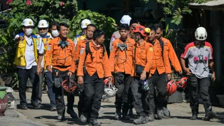Des membres des équipes de secours quittent le site de l'effondrement de l'internat islamique Al Khoziny à Sidoarjo, dans l'est de Java, le 6 octobre 2025 en Indonésie