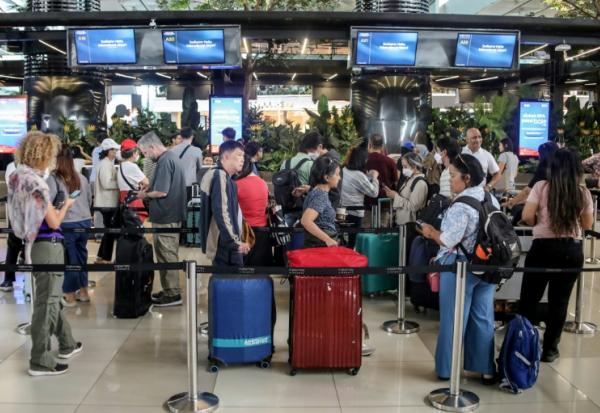 Des voyageurs bloqués à l'aéroport Soekarno-Hatta de Tangerang font la queue pour demander le remboursement de leurs billets après l'annulation de vols réguliers due à l'éruption du volcan Anak Krakatoa, le 6 septembre 2026 en Indonésie