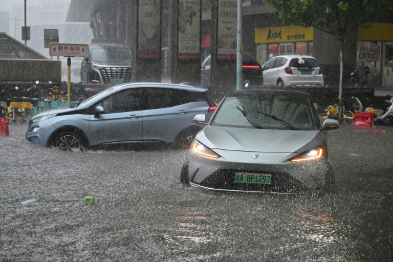 Des voitures circulent dans une rue inondée à Pékin, le 7 juillet 2026