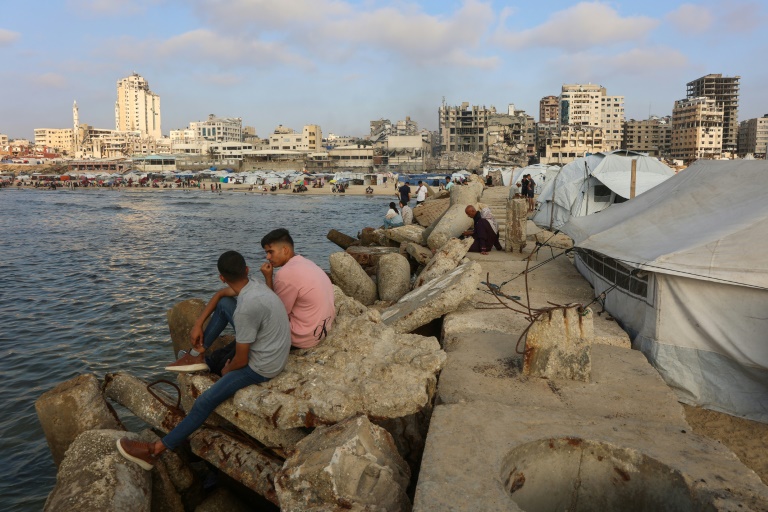Des Palestiniens se rassemblent sur la plage de Gaza-ville, en bordure de tentes intallées par des déplacés, le 8 juin 2025