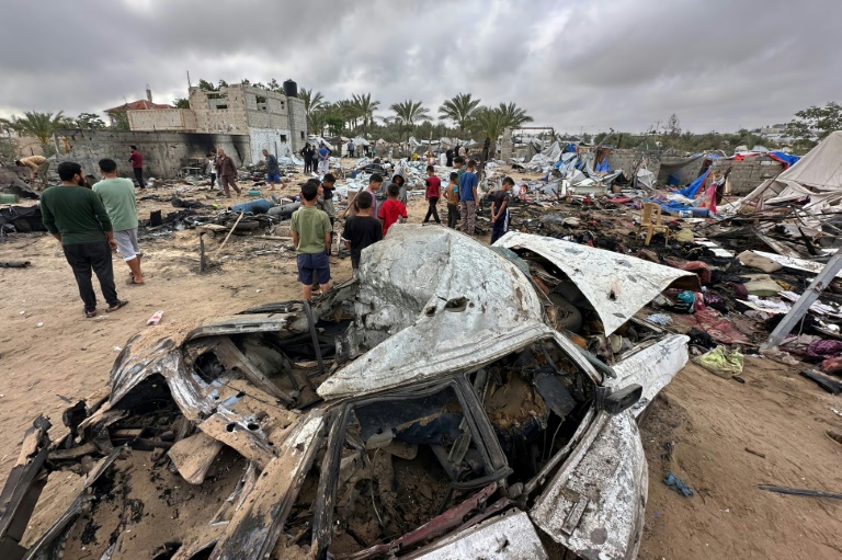 Des Palestiniens au milieu des dégâts dans le camp de déplacés à Al-Mawassi visé par des frappes israéliennes, dans le sud de la bande de Gaza, le 18 mai 2025