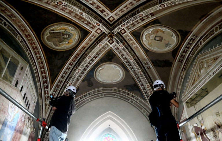 Des cameramen filment les fresques lors d'une visite de presse marquant la fin des travaux de restauration des fresques du XIVe siècle de Giotto dans la basilique Santa Croce à Florence, le 12 juin 2026