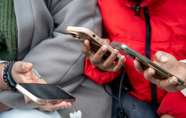 Des lycéennes regardent leurs téléphones avant d'entrer en classe au Lycée Jean Mermoz de Montsoult, le 14 janvier 2026 dans le Val-d'Oise