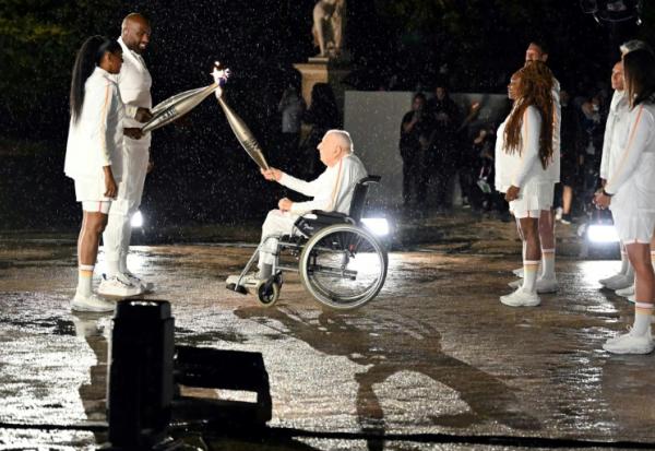 Charles Coste remettait la flamme olympique aux derniers porteurs Teddy Riner et Marie-José Pérec, lors de la cérémonie d'ouverture des Jeux de Paris 2024 le 26 juillet 2024, au Jardin des Tuileries