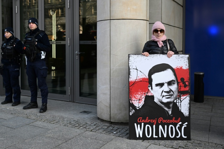 Une femme tient une pancarte avec le portrait du prisonnier Andrzej Poczobut, membre de la minorité polonaise du Belarus et correspondant de la Gazeta Wyborcza, devant le bureau du Parlement européen à Varsovie, le 14 mars 2024