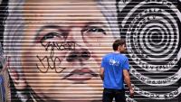 Un homme passe devant une peinture murale représentant le fondateur de WikiLeaks, Julian Assange, dans une ruelle de Melbourne, en Australie, le 26 mars 2024