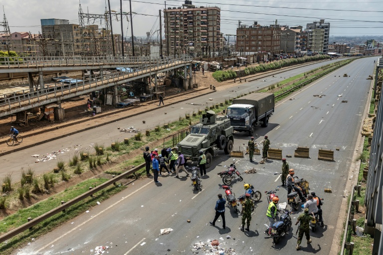 Des policiers kényans dégagent des barricades pour rétablir la circulation sur une voie rapide de Nairobi, le 18 mai 2026, jour de grève des transports et de protestation contre une nouvelle hausse des prix des carburants au Kenya