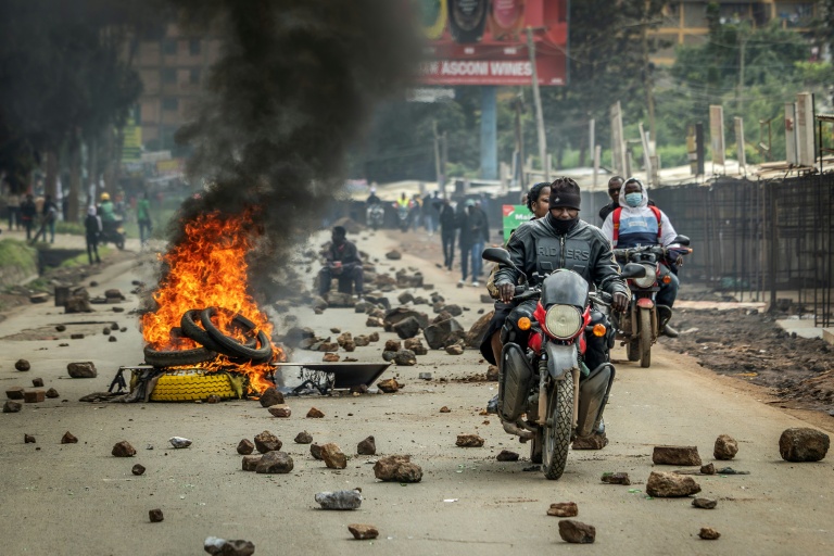 Un moto-taxi passe devant une barricade le 18 mai 2026 à Nairobi, lors d'une journée de protestation contre la hausse du prix des carburants