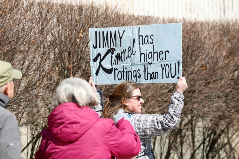 Une personne brandit une pancarte sur laquelle est écrit 