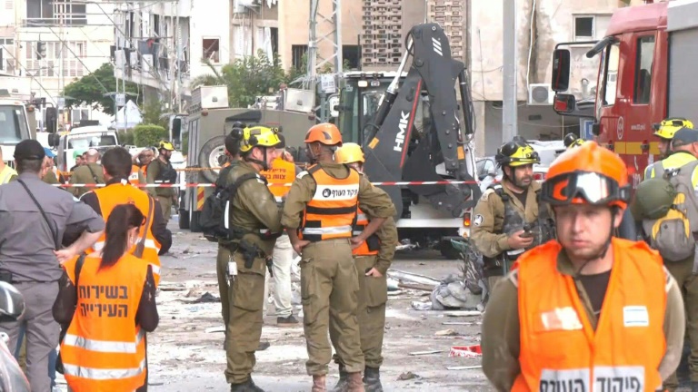 Les équipes d'urgence dégagent les débris sur le site de la frappe iranienne près de Tel-Aviv