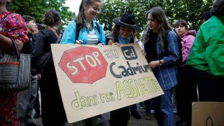 Des manifestants brandissent une pancarte sur laquelle on peut lire "Stop au cadmium dans nos assiettes" lors d'une manifestation aux côtés de députés, sur l'esplanade des Invalides à Paris, le 2 juin 2026