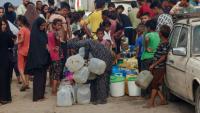 Des Palestiniens font la queue pour remplir des bidons d'eau, à al-Mawasi, dans le sud de la bande de Gaza, le 12 août 2025