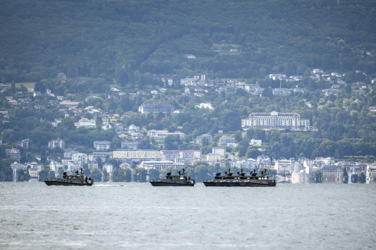 Des bateaux militaires suisses patrouillent sur le lac Léman au large de la ville d'Évian-les-Bains, avec l'Hôtel Royal (d) en arrière-plan, le 10 juin 2026 à Lausanne, en Suisse