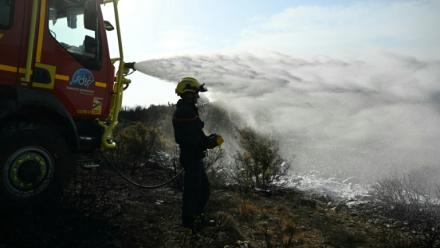Des pompiers éteignent des cendres chaudes à côté d'Albas, dans le massif des Corbières, le 9 août 2025