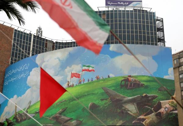 Dans le centre de Téhéran, le drapeau iranien flotte devant un vaste panneau anti-américain, le 8 février 2026