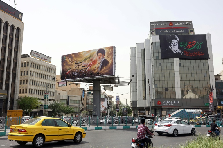 Des automobilistes passent devant d'immenses panneaux publicitaires arborant des photos de l'ayatollah Ali Khamenei, le défunt guide suprême de l'Iran, le 2 juillet 2026 à Téhéran, à la veille de ses funérailles