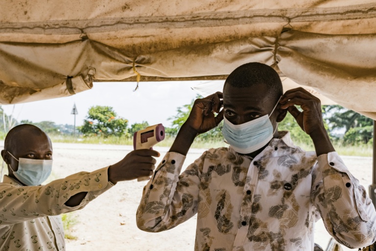 Un agent sanitaire à la frontière du poste de Busunga, entre l'Ouganda et la République démocratique du Congo, prend la température d'un voyageur à l'aide d'un thermomètre infrarouge sans contact à Bundibugyo, le 18 mai 2026. 
