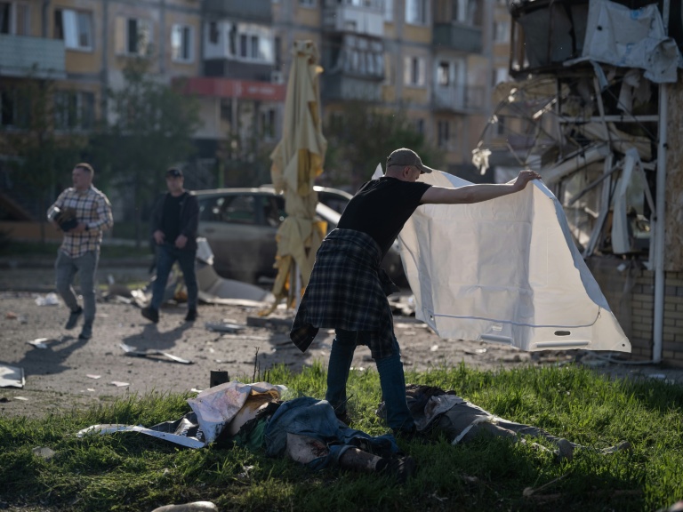 Un homme couvre d'un drap les corps de victimes de frappes russes à Kramatorsk, dans l'Est de l'Ukraine, le 5 mai 2026