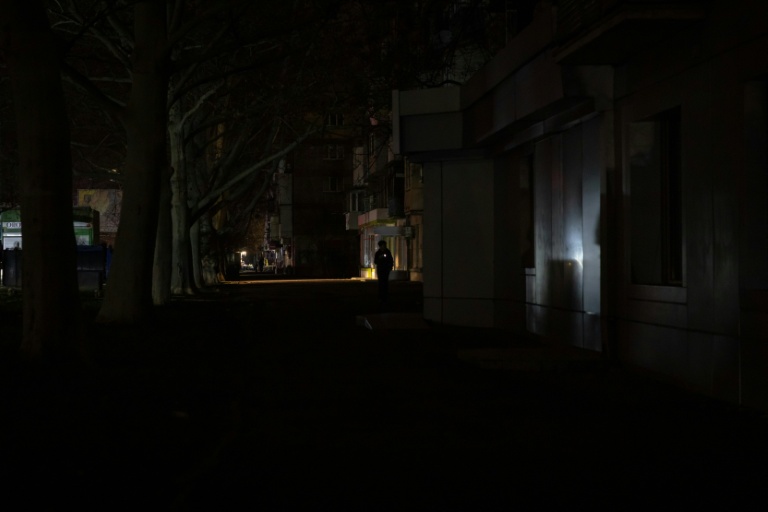 Une rue plongée dans l'obscurité lors d'une panne de courant à Odessa, dans le sud de l'Ukraine, après des attaques de missiles et de drones russes contre les infrastructures énergétiques ukrainiennes, le 22 décembre 2025 