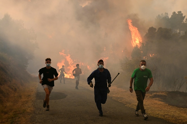 Des personnes fuient les flammes à Larouco, dans le nord-ouest de l'Espagne, le 13 août 2025