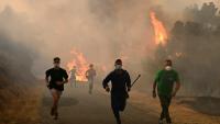 Des personnes fuient les flammes à Larouco, dans le nord-ouest de l'Espagne, le 13 août 2025