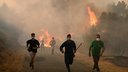 Des personnes fuient les flammes à Larouco, dans le nord-ouest de l'Espagne, le 13 août 2025