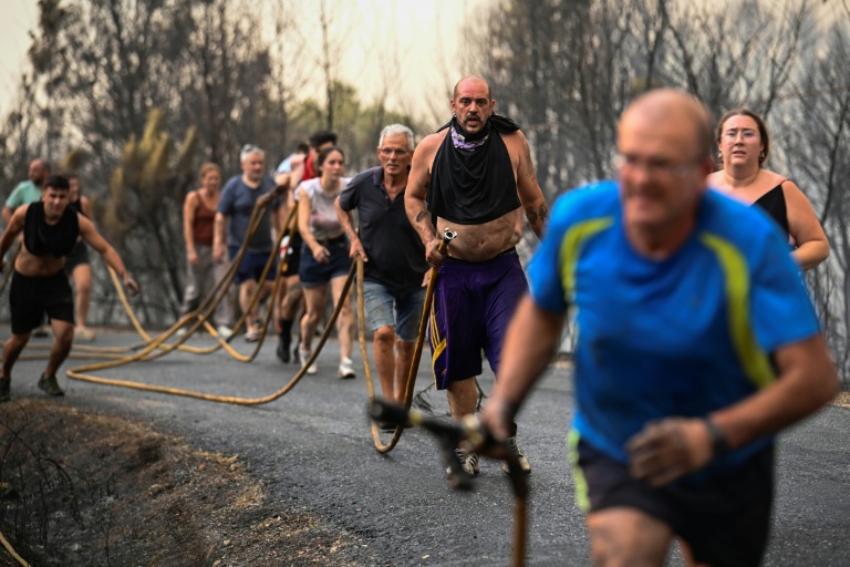 Des personnes tentent d'éteindre l'incendie à Larouco, dans le nord-ouest de l'Espagne, le 13 août 2025