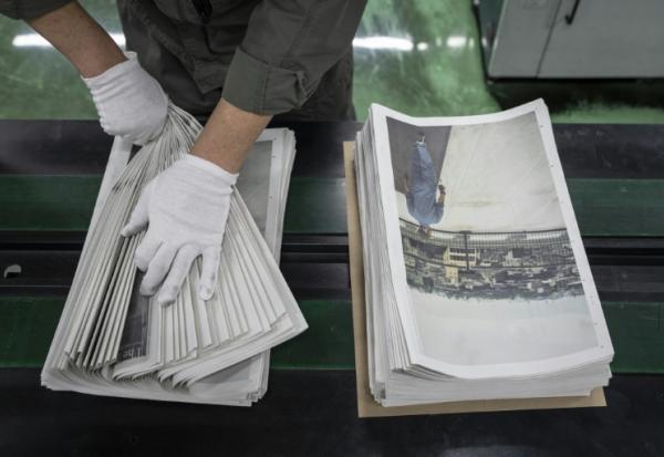 Un employé emballe l'œuvre du photographe Kazuma Obara, "The Newspaper", à Kumiyama, dans la préfecture de Kyoto, au Japon, le 19 mars 2026