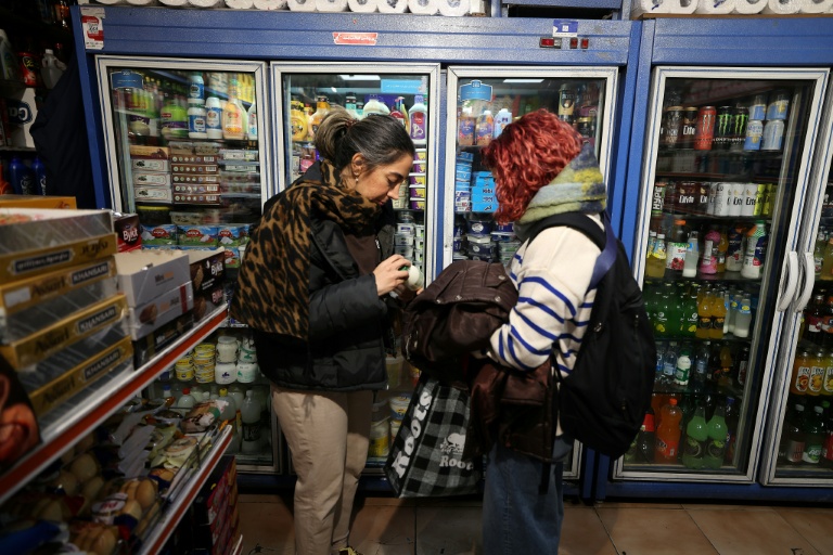 Une femme vérifie le prix du lait dans une boutique de Téhéran, en Iran, le 7 janvier 2026