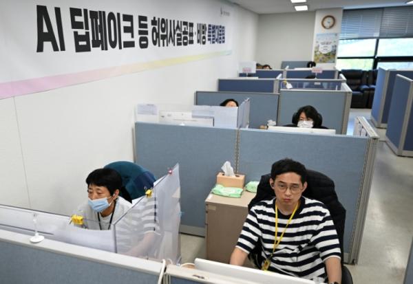 Des employés à la recherche de contenus générés par intelligence artificielle sur les réseaux sociaux lors des campagnes électorales, au siège de la Commission nationale électorale (NEC) à Gwacheon, en Corée du Sud, le 16 avril 2026 
