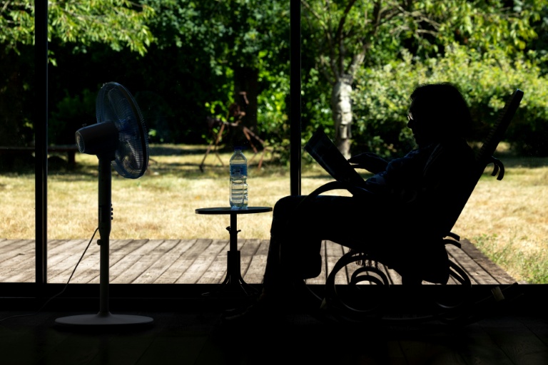 Une personne âgée assise devant un ventilateur en plein épisode de canicule à Pont-Audemer, dans l'Eure, le 12 juillet 2026