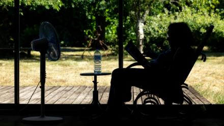 Une personne âgée assise devant un ventilateur en plein épisode de canicule à Pont-Audemer, dans l'Eure, le 12 juillet 2026