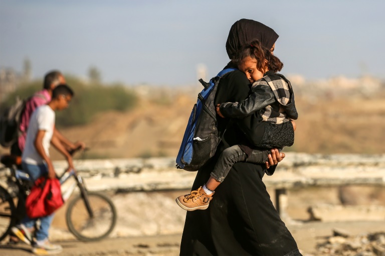 Des Palestiniens marchent le long de la route côtière dans le centre de la bande de Gaza en direction de la ville de Gaza, dans le nord, le 11 octobre 2025