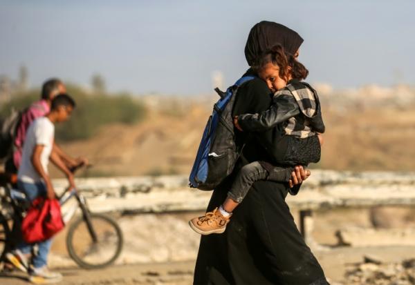 Des Palestiniens marchent le long de la route côtière dans le centre de la bande de Gaza en direction de la ville de Gaza, dans le nord, le 11 octobre 2025