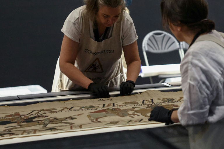 Des employées préparent la tapisserie de Bayeux présentée aux médias au British Museum, le 17 juillet 2026 à Londres