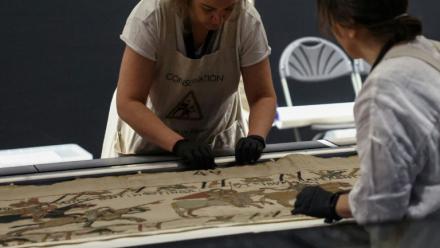 Des employées préparent la tapisserie de Bayeux présentée aux médias au British Museum, le 17 juillet 2026 à Londres