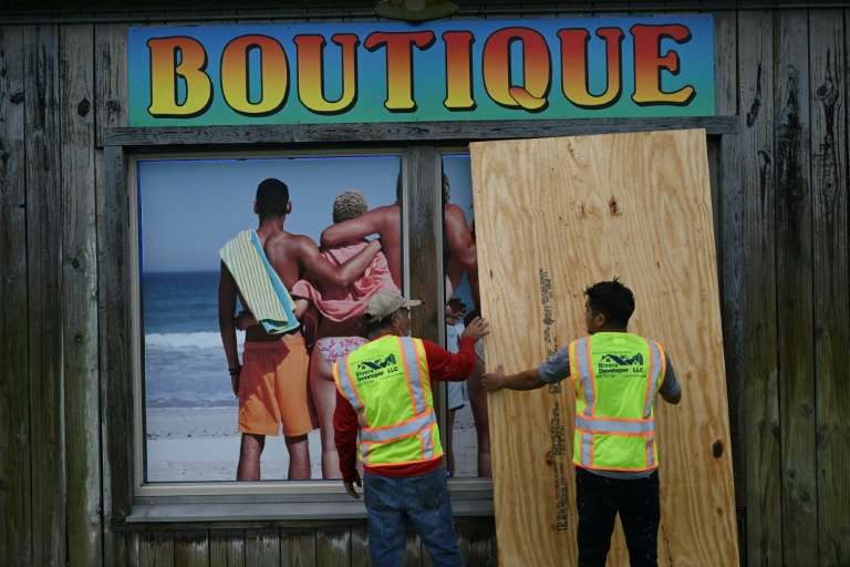 Des ouvriers barricadent la devanture d'un magasin à Pensacola Beach, avant l'arrivée de l'ouragan Isaias, le 9 octobre 2026 en Floride