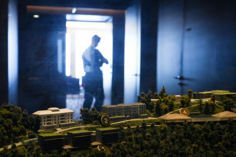Un policier passe devant une maquette du complexe hôtelier de luxe du Bürgenstock, surplombant le lac des Quatre-Cantons, le 21 juin 2026 près de Lucerne, en Suisse