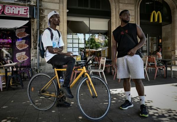 Des livreurs à vélo font une pause près des restaurants en attendant des commandes, à Bordeaux, le 7 juillet 2026 lors d'une vague de chaleur en France
