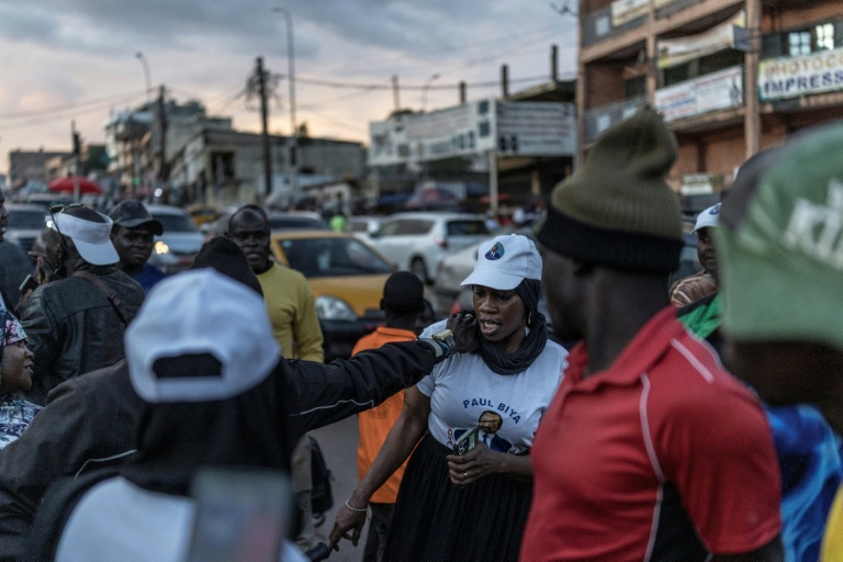 Une femme portant un t-shirt du président sortant du Cameroun, Paul Biya, est prise à partie par des chauffeurs de moto-taxis soutenant le candidat d'opposition Issa Tchiroma, à Yaoundé le 11 octobre 2025