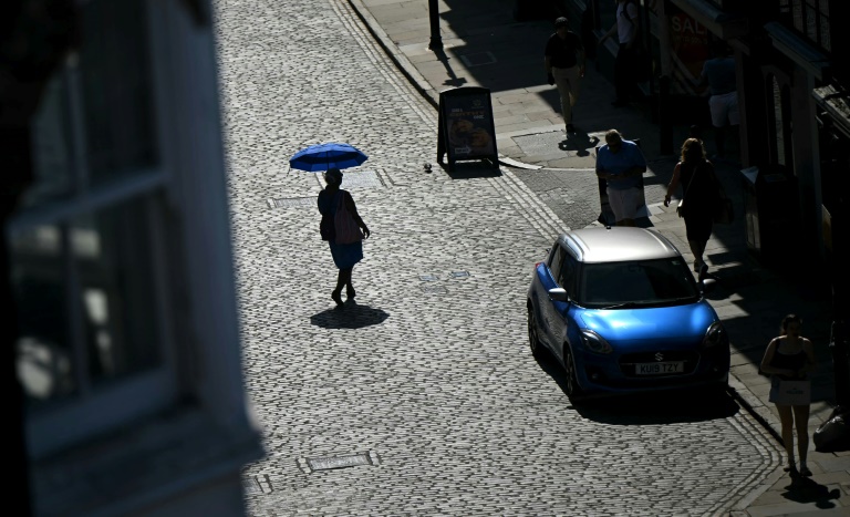 Une personne se protège du soleil sous une ombrelle, le 25 juin 2026 à Guildford, au Royaume-Uni, lors d'un épisode de canicule en Europe