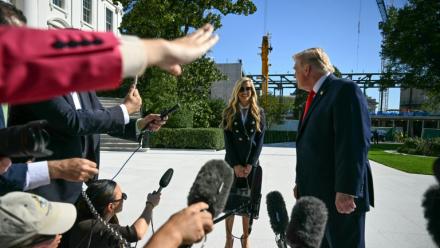 Le président américain Donald Trump se tourne vers la nouvelle porte-parole de la Maison Blanche, Kate Zacharia, devant la presse à Washington le 13 octobre 2026