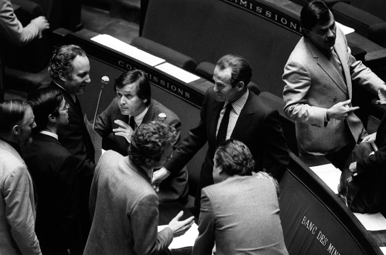 Des députés félicitent le ministre de la Justice Robert Badinter (c) dans l'hémicycle de l'Assemblée nationale après l'examen de son projet de loi sur l'abolition de la peine de mort, le 17 septembre 1981 à Paris 