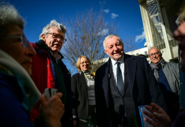 Jean-Michel Aulas (2e D), en campagne pour la mairie de Lyon, et l'ancien ministre Jean-Louis Borloo le 4 février 2026 lors d'une visite dans le quartier de la Duchère à Lyon