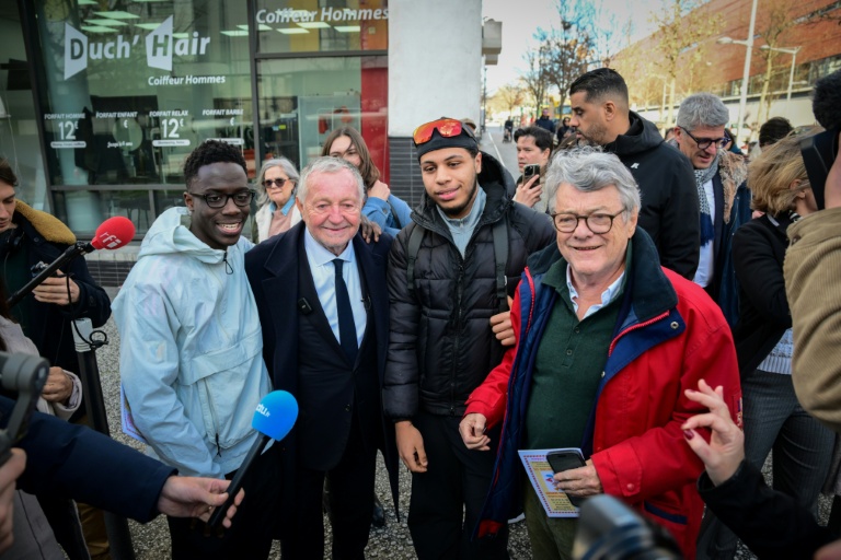 Jean-Michel Aulas (C), en campagne pour la mairie de Lyon, et l'ancien ministre Jean-Louis Borloo le 4 février 2026 lors d'une visite dans le quartier de la Duchère à Lyon