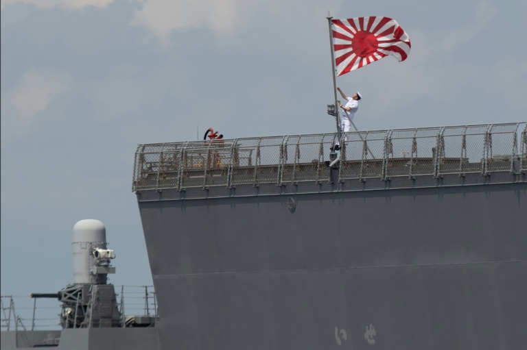 Un marin hisse le pavillon des Forces maritimes d'autodéfense japonaises à bord du JS Ise, un destroyer porte-hélicoptères de classe Hyuga, lors de son arrivée au port international de Manille, le 21 juin 2025 aux Philippines