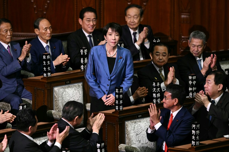 La présidente du Parti libéral démocrate (PLD) Sanae Takaichi (c) est applaudie après avoir été nommée nouvelle Première ministre du Japon lors d'une session extraordinaire de la chambre basse du Parlement à Tokyo, le 21 octobre 2025