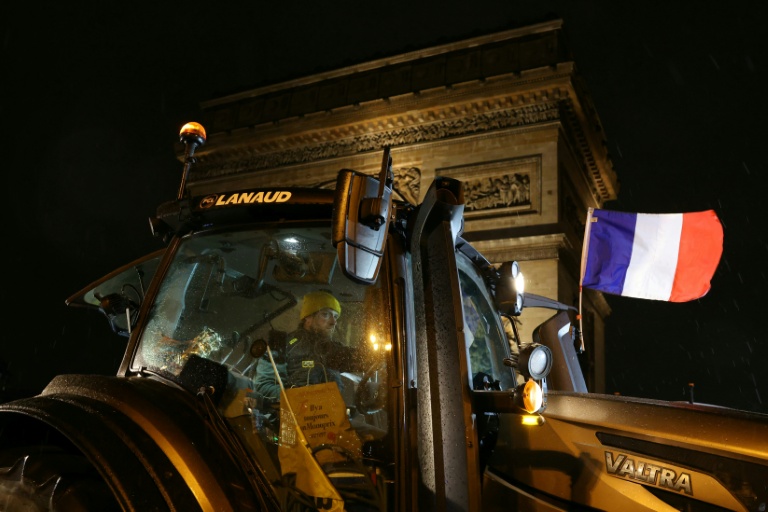 Un tracteur arborant le drapeau français est garé devant l'Arc de Triomphe lors d'une manifestation d'agriculteurs, le 8 janvier 2026 à Paris