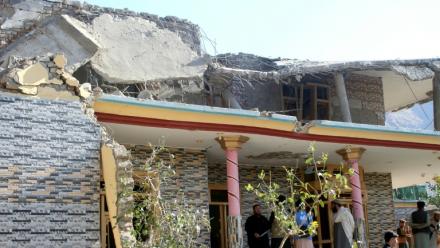 Des Afghans se rassemblent devant une maison endommagée par une frappe pakistanaise à Asadabad dans l'est de l'Afghanistan le 25 novembre 2025