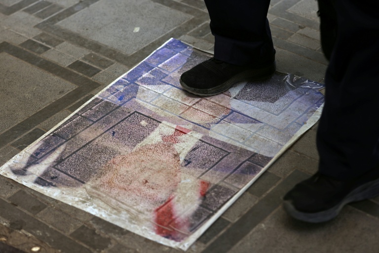 Un Iranien marche sur un portrait du président américain Donald Trump installé sur le sol de la ville-frontière de Zurbatiyah, en Irak, le 29 juillet 2026